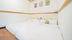 Un dormitorio con una cama grande, cabecera de madera y una pequeña estantería con una lámpara.