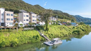 A riverside hotel with a boat dock, a staircase leading to the water, and a sign reading 'Eldorado.' - Chuncheon El Dorado Kid's Pension (Chuncheon)