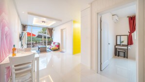 A modern hotel room with a dining area, a sofa, a bathroom with a mirror and red curtains, and a view of the outdoors. - Gapyeong Rialto Pension (Gapyeong)