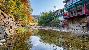 Un canal estrecho con un reflejo nítido, bordeado por terreno rocoso y vegetación.