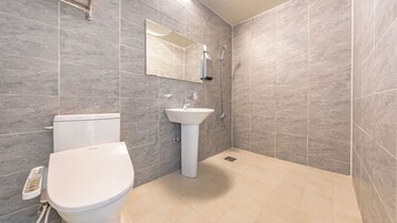 Un baño moderno con inodoro, lavabo y ducha.