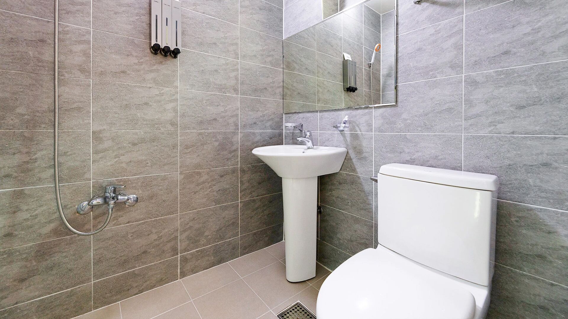 Ein modernes Badezimmer mit Waschbecken, Toilette und Dusche, alles in Weiß.