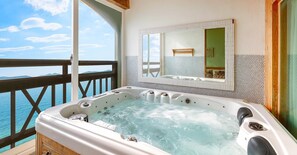 A hot tub with a view of the sea, a wooden deck, and a tiled wall with a mirror. - Ganghwa Hana & Alice spa Pension (Incheon)