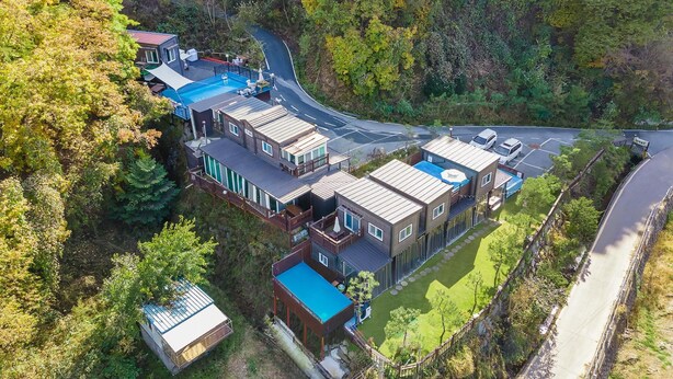 A modern residential complex with multiple houses, a swimming pool, and a curved road. - Gapyeong Myeonyeokgongbang Private Villa (Gapyeong)