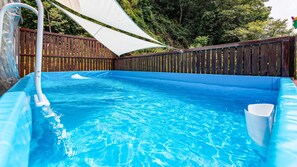 A swimming pool with a wooden deck and a white shade sail. - Gapyeong Myeonyeokgongbang Private Villa (Gapyeong)