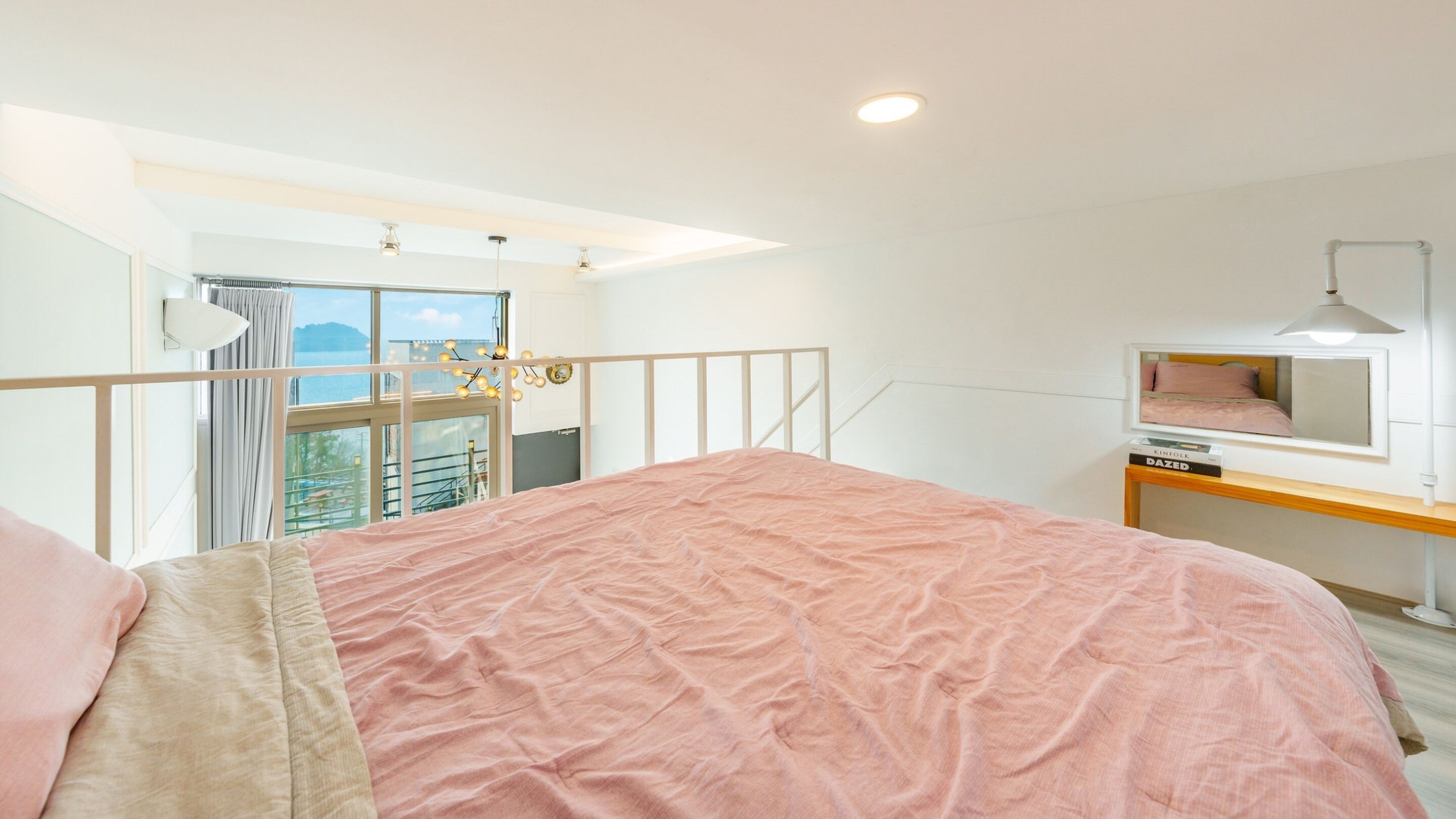 Une chambre avec un grand lit, un bureau, une chaise, une fenêtre avec des rideaux et une vue sur l’extérieur.