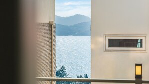Quarto com vista para um lago e montanhas.
