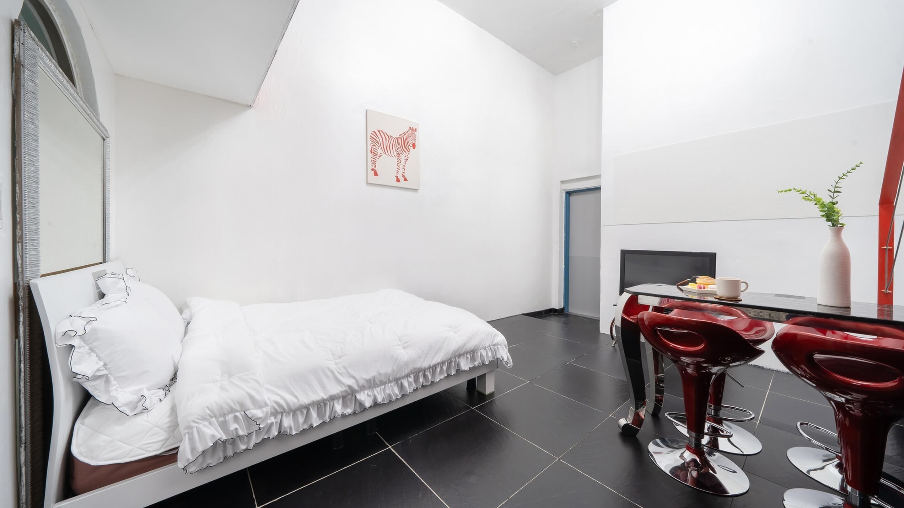 A modern bedroom with a bed, a desk, and a chair.