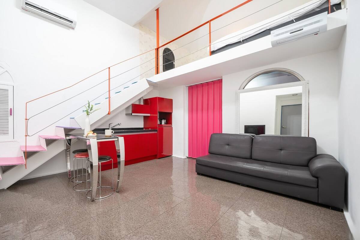 A modern apartment with a kitchen, a dining area, a living room, and a staircase.
