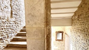 A stone staircase leading to a higher level, with a framed picture on the wall at the top.