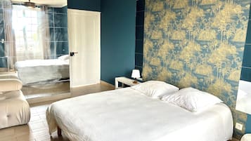 A hotel room with a bed, a chair, a nightstand, and a patterned wall.