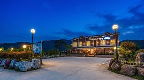 A two-story building with a balcony, a signboard, and a well-lit entrance. - Suncheonman Muhan Dojan Pension (Suncheon)