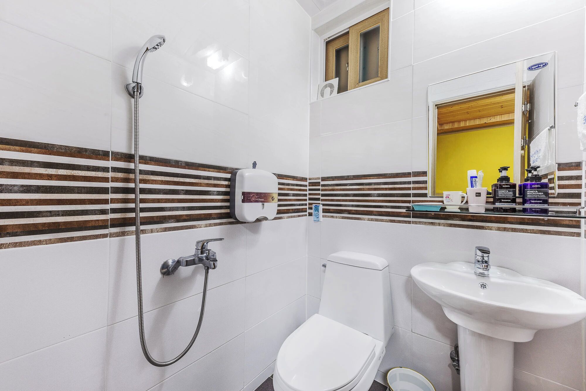 A bathroom with a shower, toilet, and sink.
