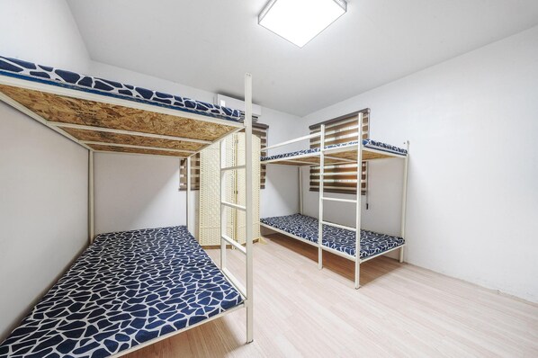 A room with bunk beds, wooden flooring, and a white wall. - Yangyang Slowstay Pension (Yangyang)