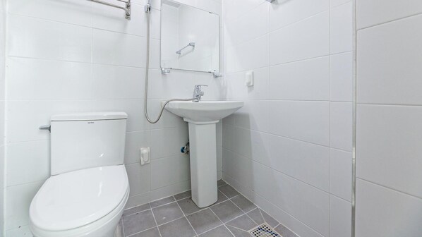 A small, clean bathroom with a toilet, sink, and shower. - Ganghwa Paeng Namu Pension (Incheon)
