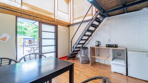 A modern kitchen with a wooden table, a built-in stove, and a staircase leading to an upper level. - Nami Island Healing Leisure Camping&glamping (Gapyeong)