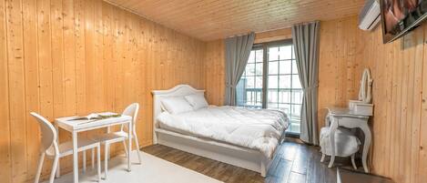 Una habitación con paneles de madera, una cama, un escritorio y una silla.
