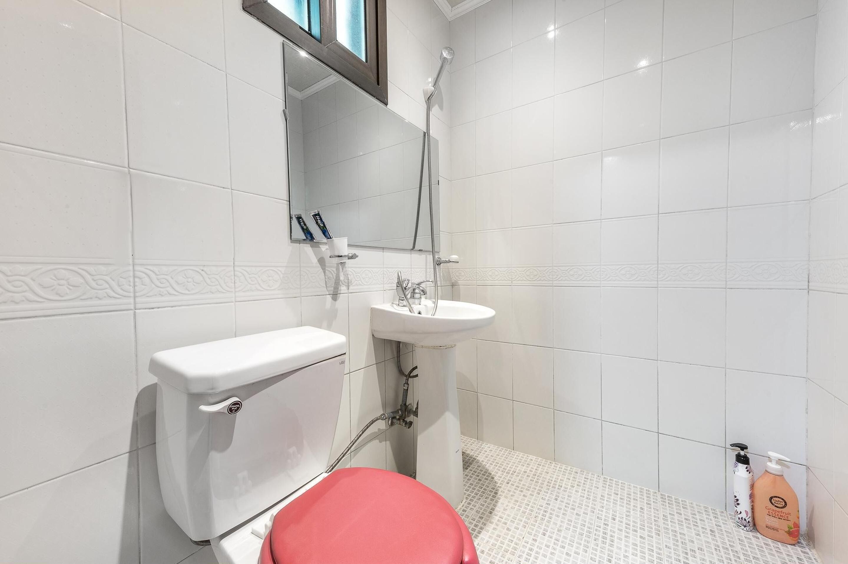 A bathroom with a toilet, sink, and shower.