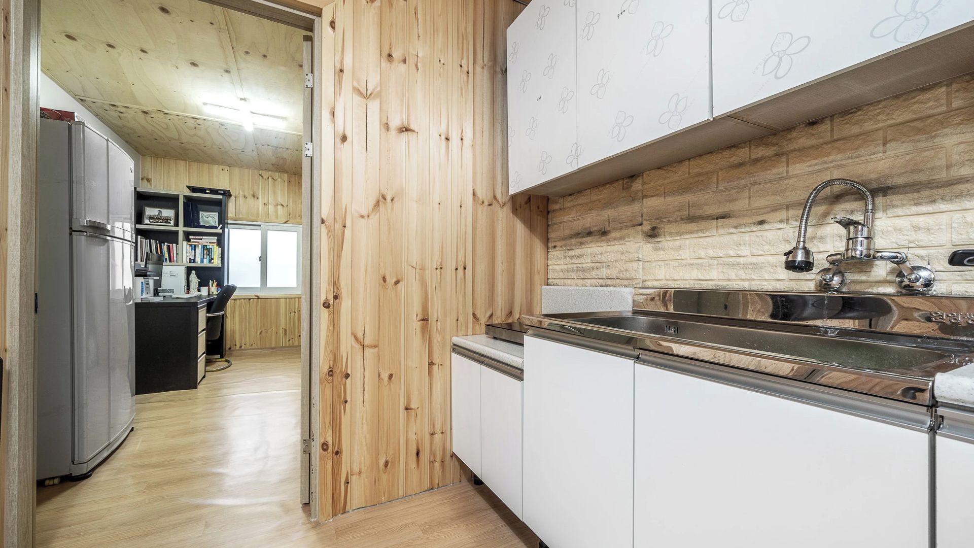 Una cocina moderna con armarios de madera y un lavamanos de acero inoxidable.