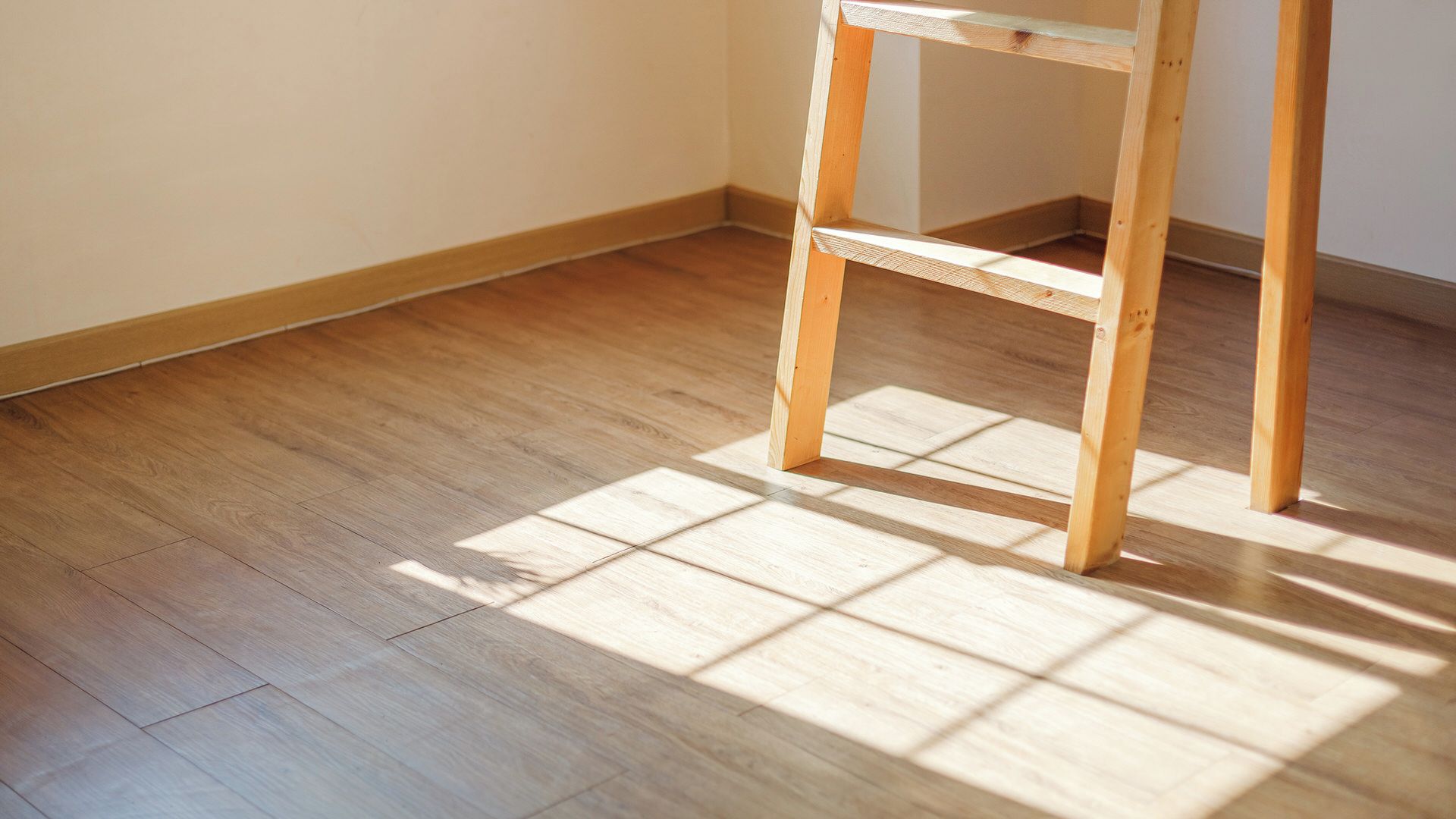A wooden floor with a corner table.