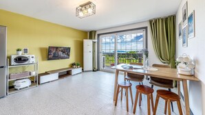 A modern kitchen with a dining area, a large window with a view, and a ceiling light fixture. - Ganghwa Rodemhouse Pension (Incheon)