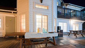 A wooden deck with picnic tables and a covered seating area. - Gangnueng Gadunji Pension (Gangneung)