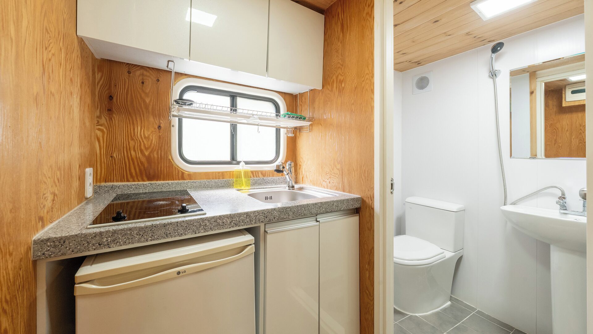 A compact kitchen with a window, a sink, and a dishwasher.