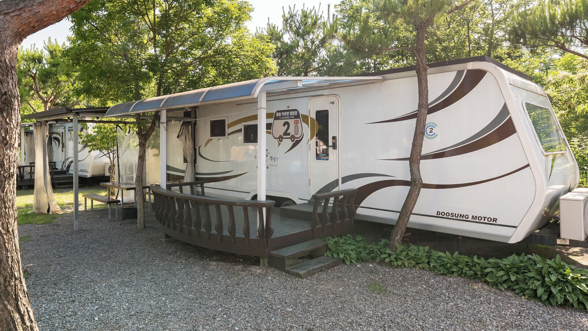 Ein Wohnmobil mit überdachter Veranda und einer Rampe zum Eingang.