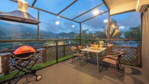 A covered outdoor patio with a grill, dining table, chairs, and a view of the landscape. - Gapyeong Dangdangi Pet Poolvilla Blue (Gapyeong)
