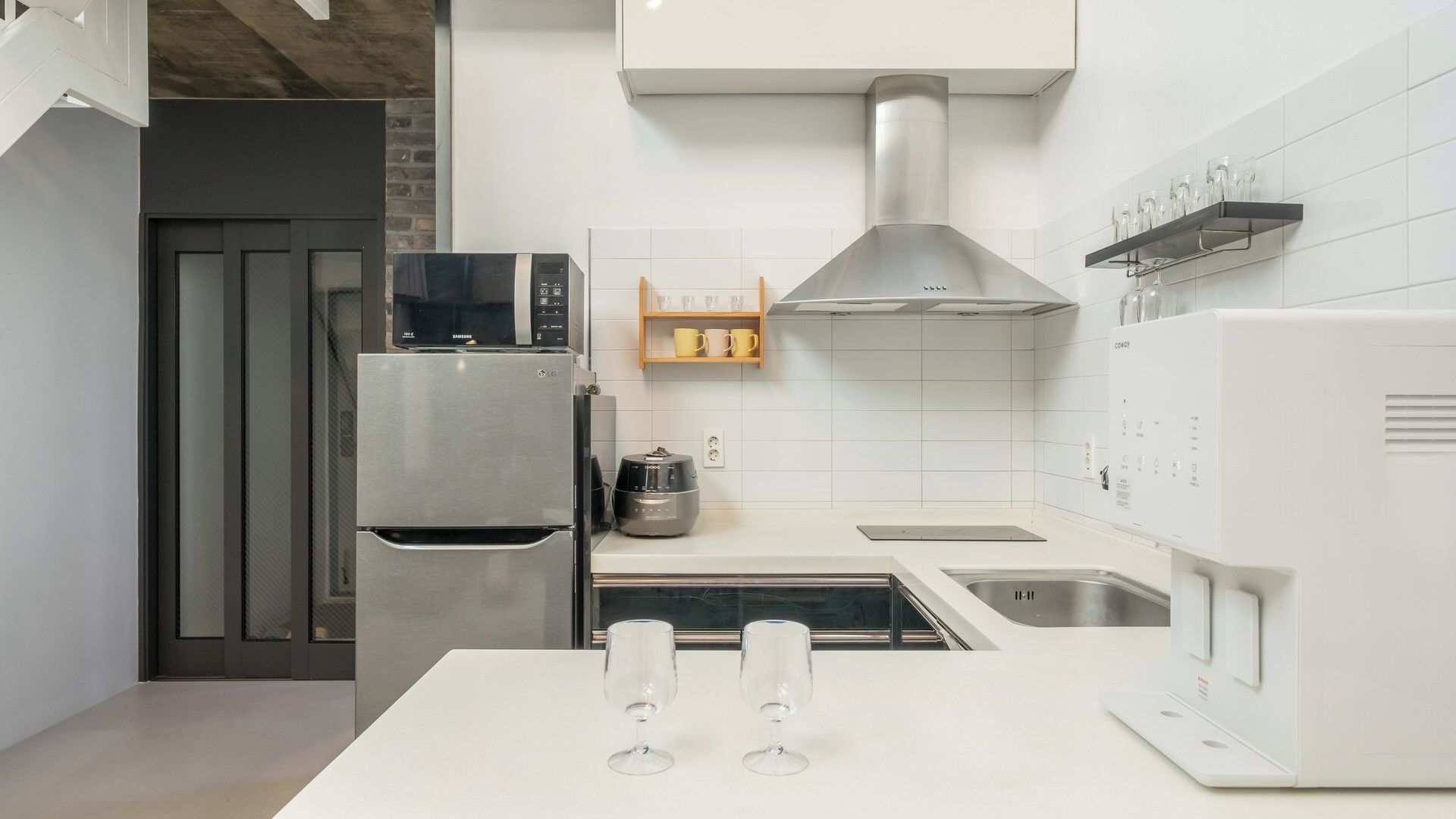 Una cocina moderna con electrodomésticos de acero inoxidable, horno empotrado y cafetera.