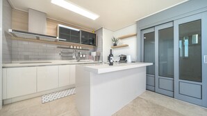 Una cocina moderna con armarios blancos, una isla central y un horno empotrado.