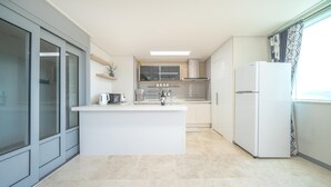 Una cocina moderna con una isla central, horno empotrado y refrigerador.