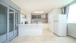 Una cocina moderna con una isla central, horno empotrado y refrigerador.
