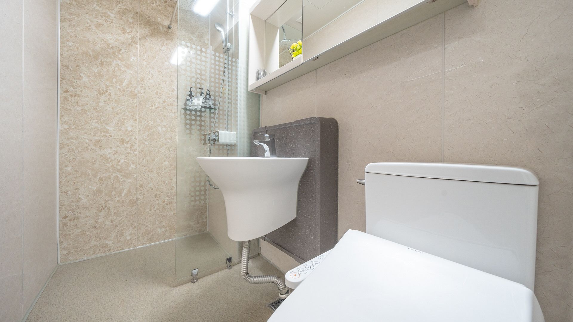 A bathroom with a toilet, sink, and shower.