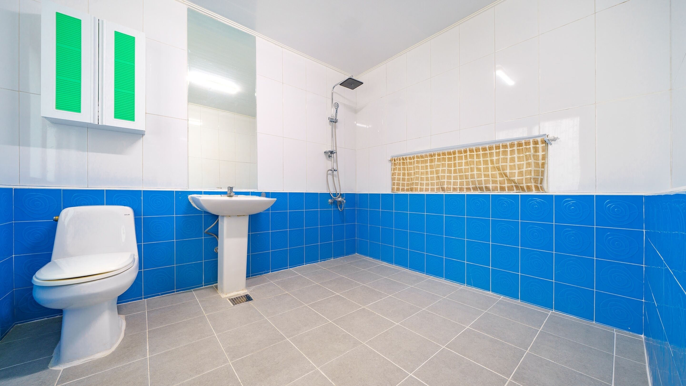 A bathroom with a toilet, sink, and shower.
