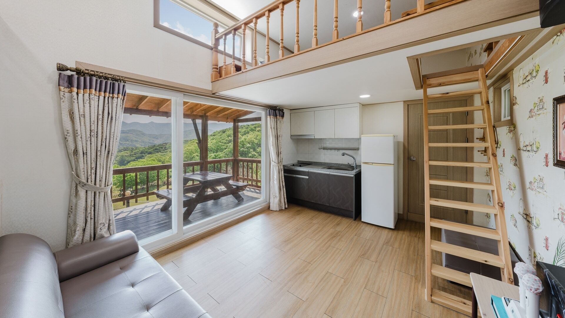 Un espace de vie compact doté d’un balcon, d’une kitchenette et d’un espace en mezzanine.