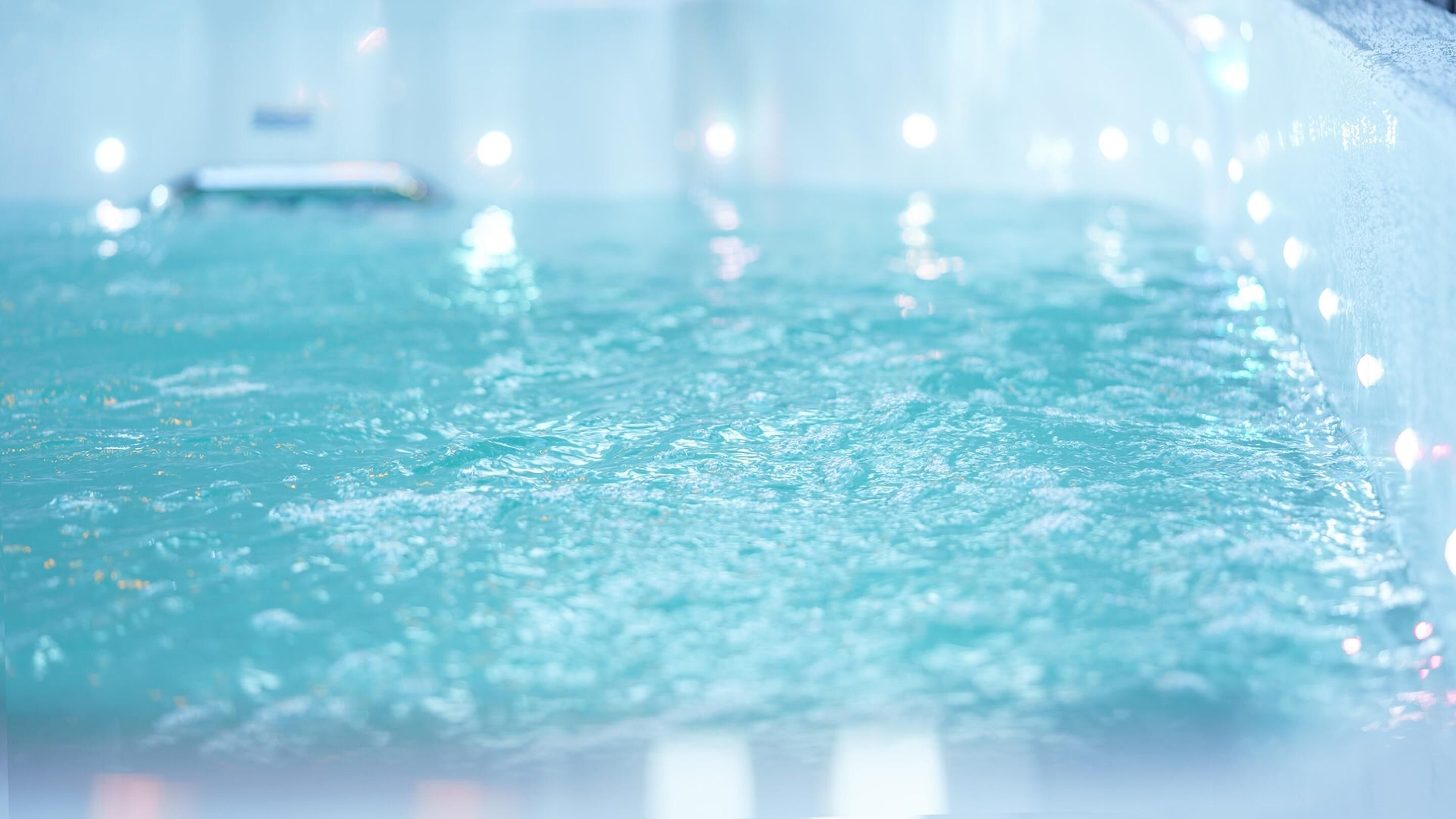 En närbild av en vattenyta med bubblor, troligen i en pool eller ett spa.