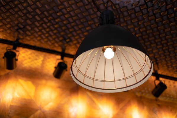A ceiling with a patterned design and a hanging light fixture.