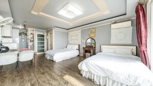 A hotel room with two beds, a desk, a chair, a wardrobe, and a ceiling fan. - Ganghwa Badatgashimteo Pension (Incheon)