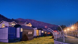 A row of mobile homes with a wooden deck and a starry night sky. - Gapyeong Poongkyungmaru Pension (Gapyeong)