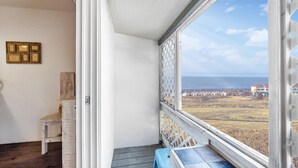 A balcony with a view of a vineyard and distant buildings. - Ganghwa Vintage Box Pension (Incheon)