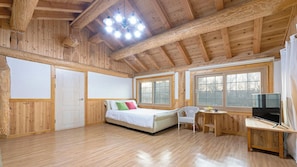 A wooden cabin bedroom with a bed, a desk, and a TV. - Ganghwa Izba Pension (Incheon)