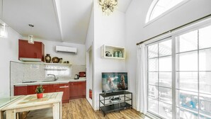 A compact living space with a kitchenette, a dining area, and a large window providing a view of the outdoors. - Ganghwa Edenjungwon Pension (Incheon)