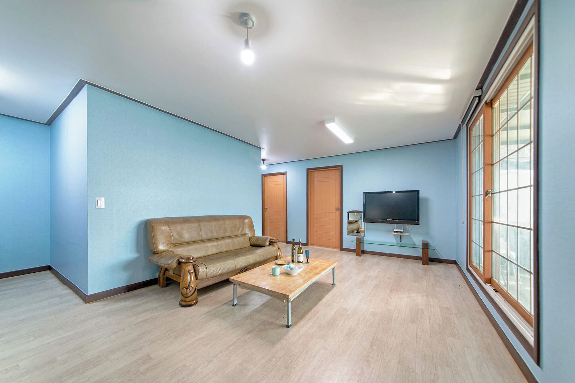 A living room with a sofa, coffee table, and television.