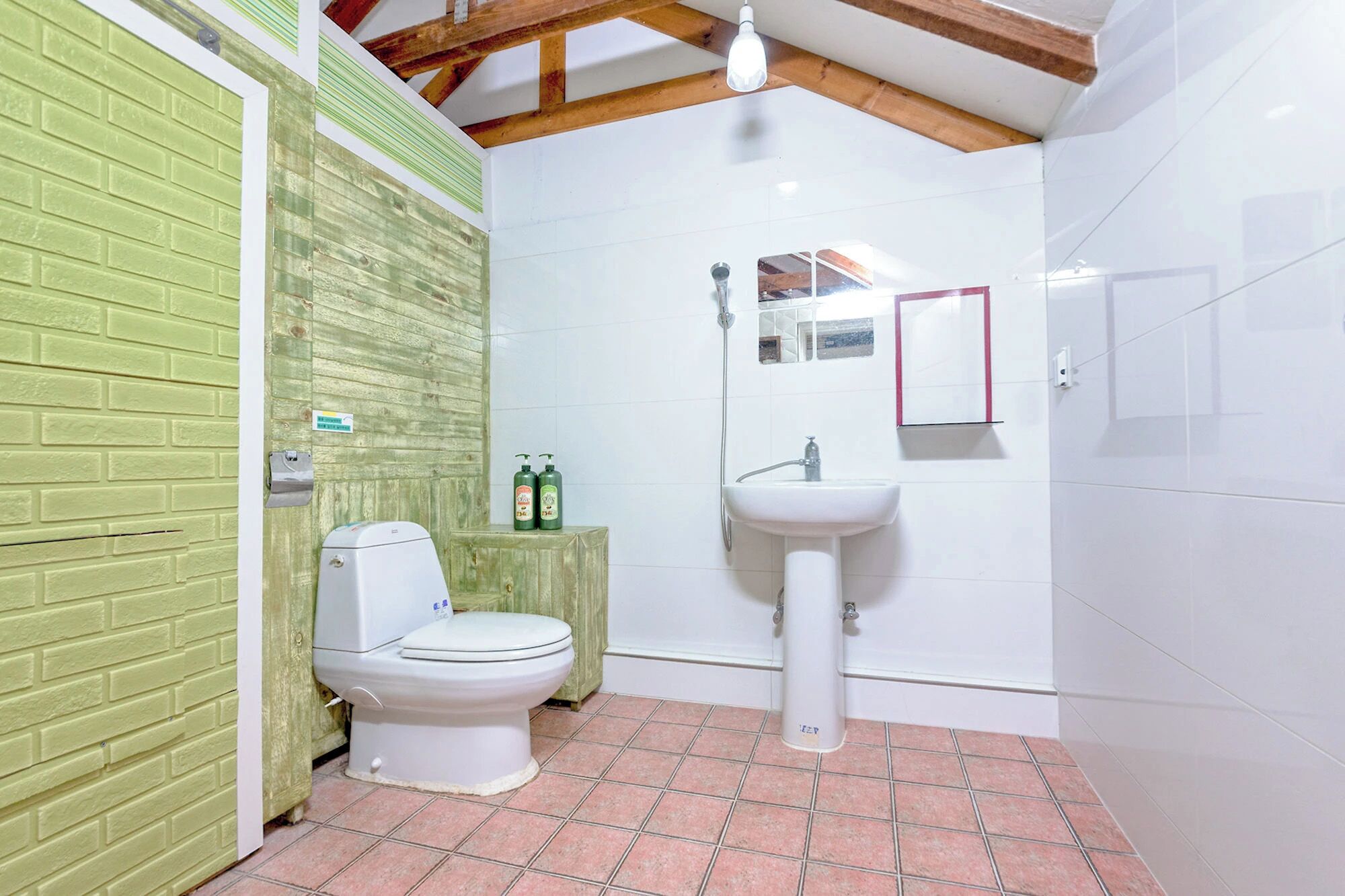 A bathroom with a toilet, a sink, and a mirror.