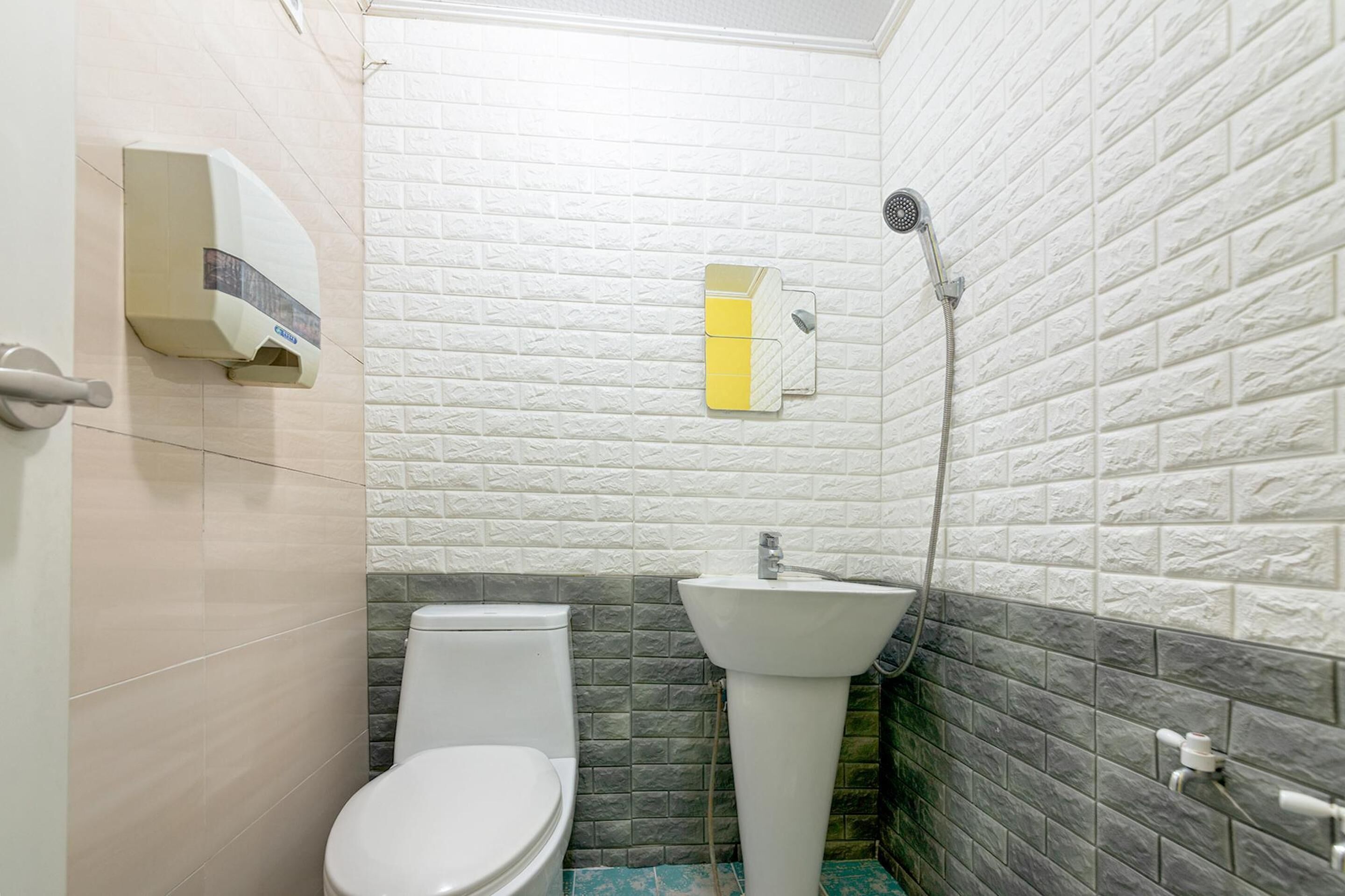 Un baño pequeño con inodoro, lavamanos y ducha.