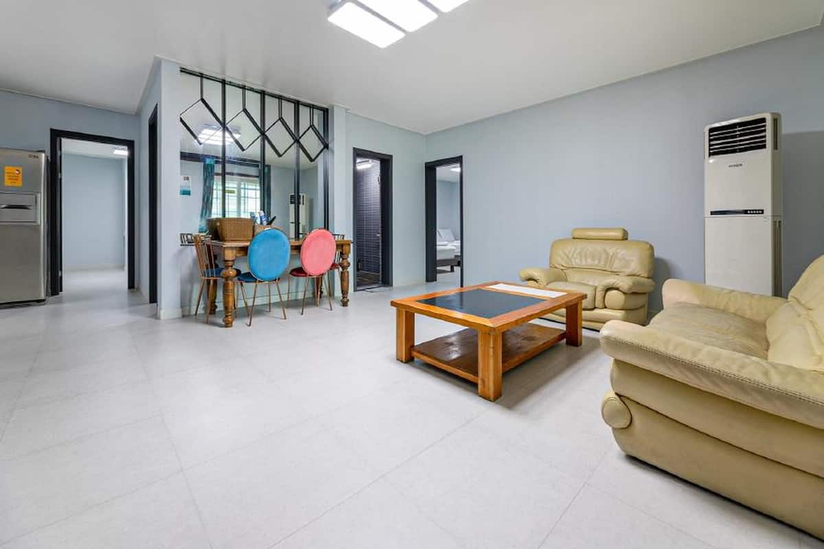Un salon moderne comprenant un canapé, une table basse et un coin repas avec des chaises.