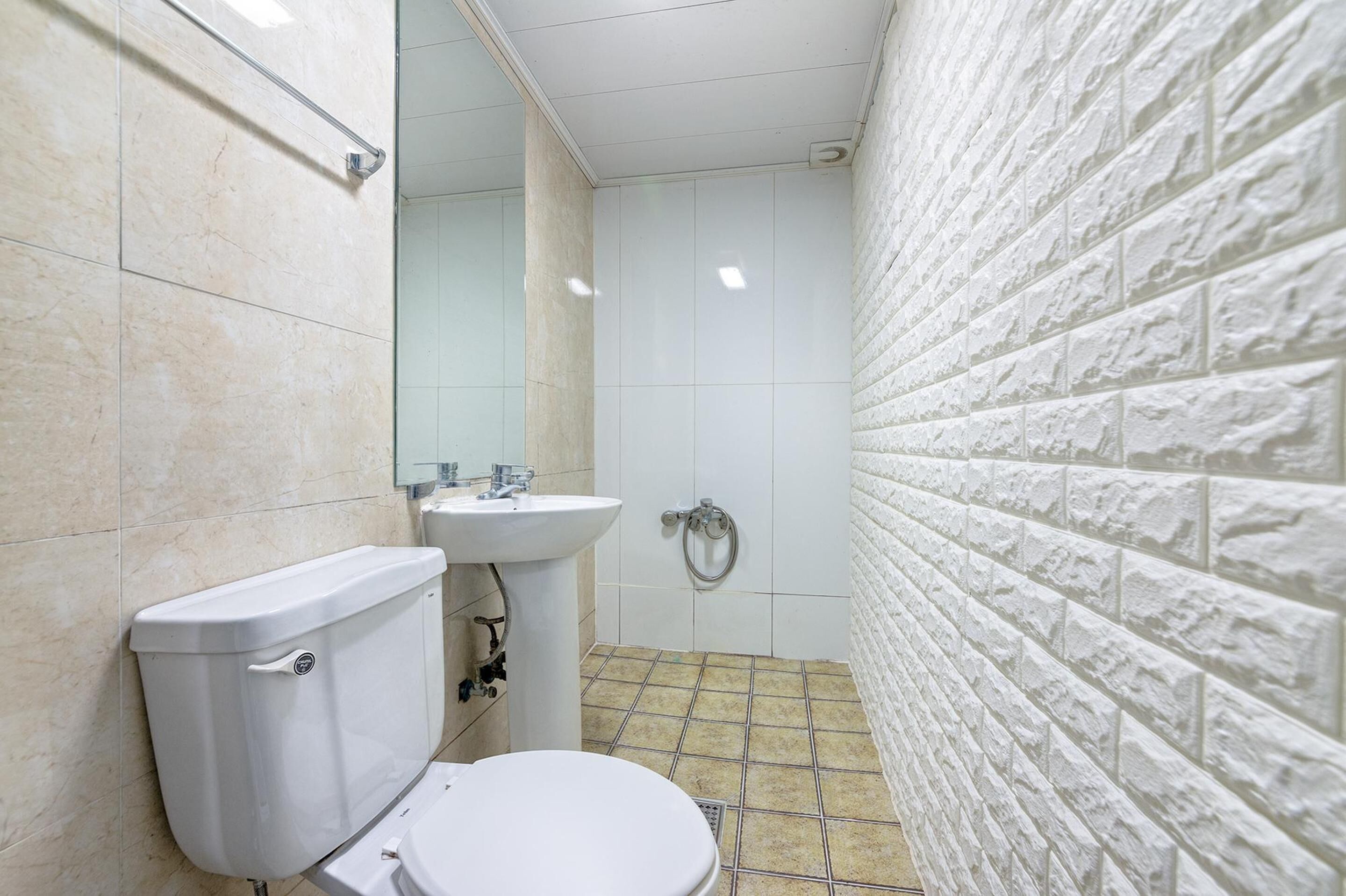 A bathroom with a toilet, sink, and shower.
