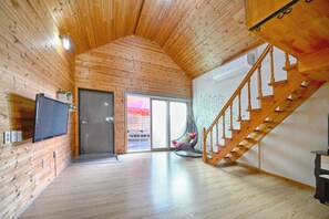 Enjoy a spacious retreat with a flat-screen TV, wooden staircase, and sliding glass door leading to an outdoor area.