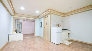 A compact kitchen with a refrigerator, a stove, and a small countertop.